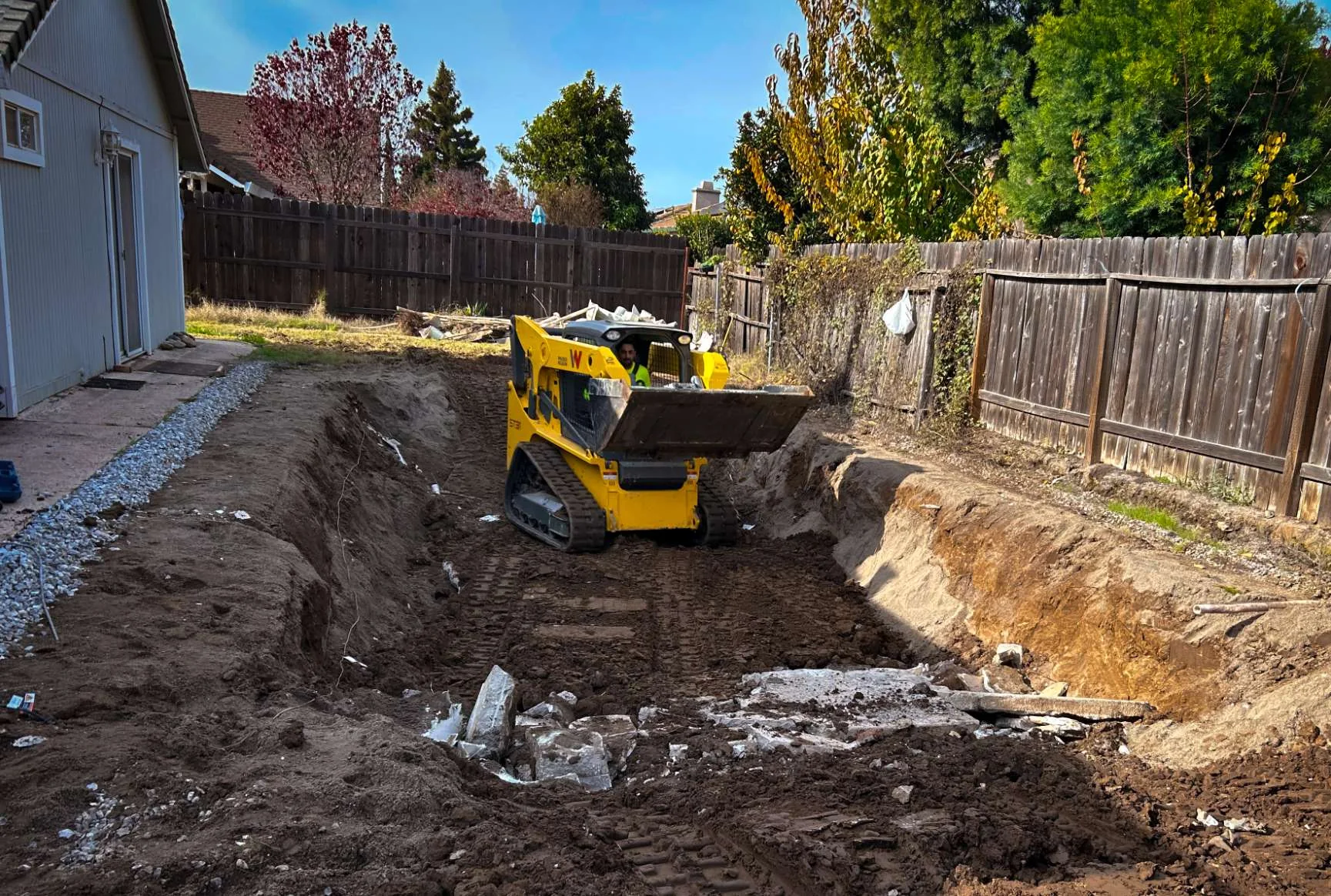 Skid steer hauling pool debris