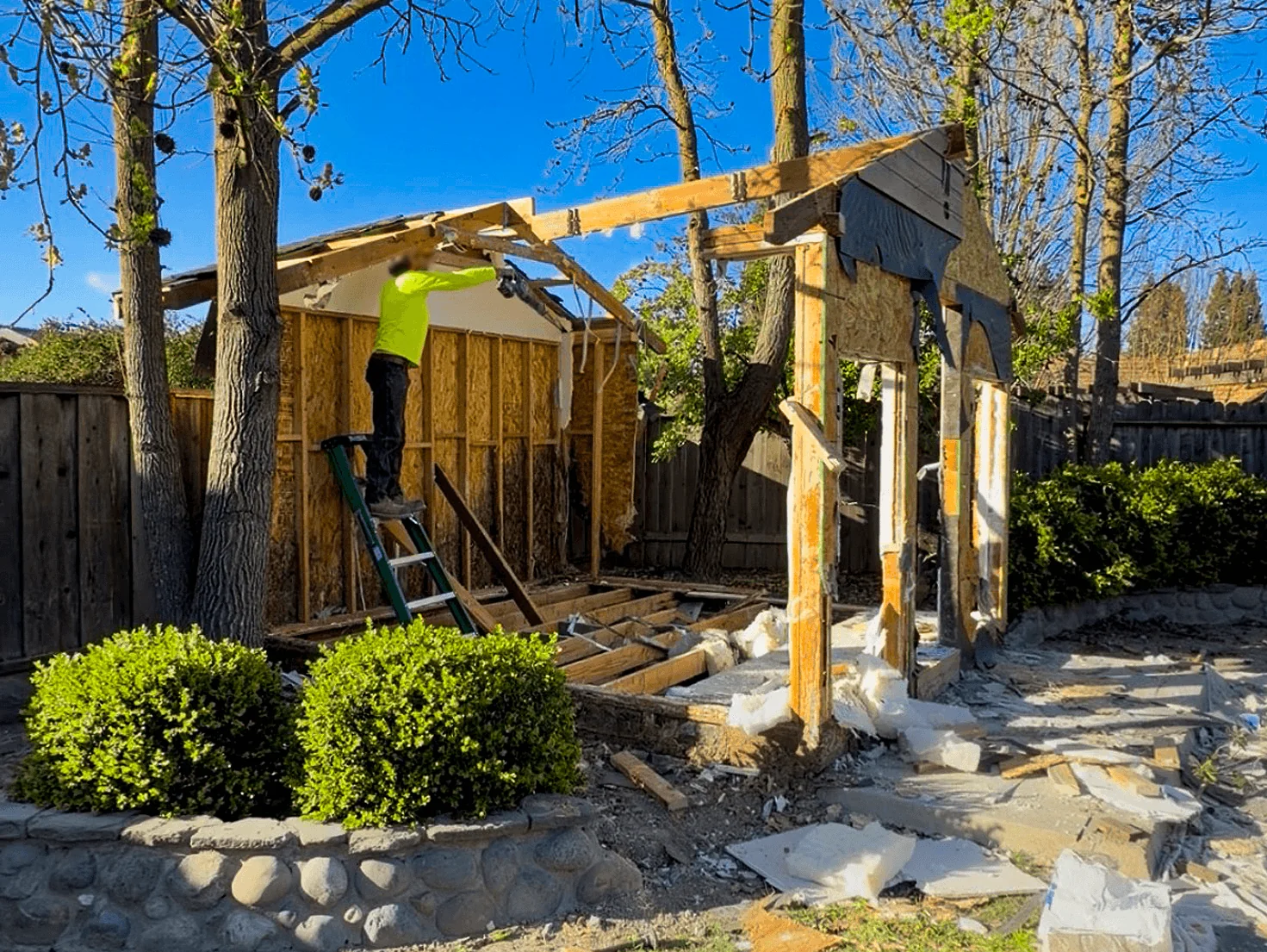 Crew tearing down a backyard shed